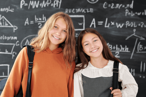 girls in front of blackboard